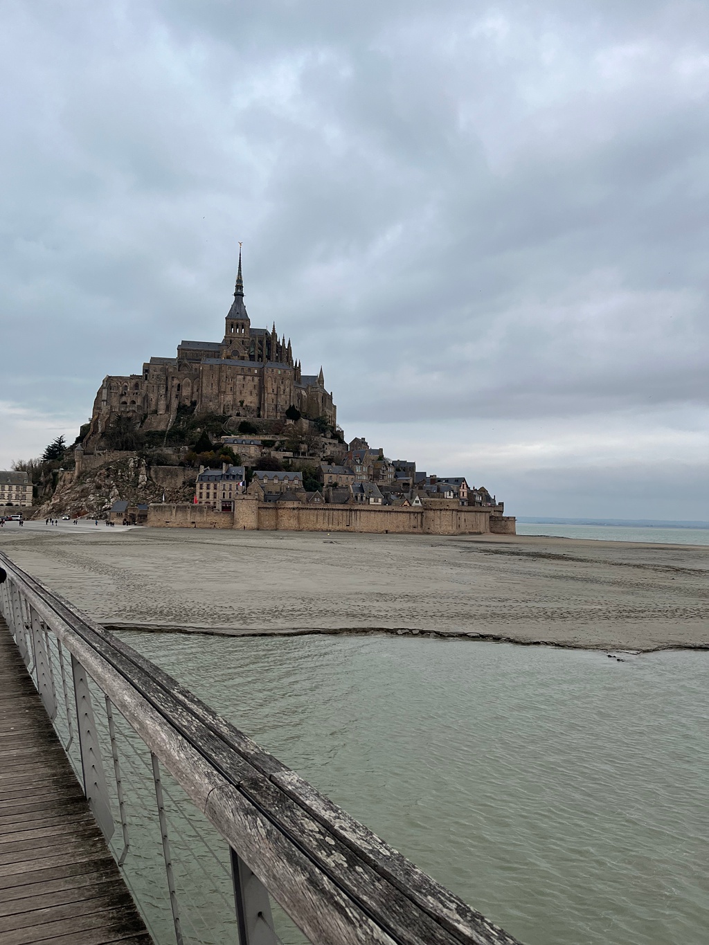 The wooden dock approach to the island of Mont Saint Michel in the distance