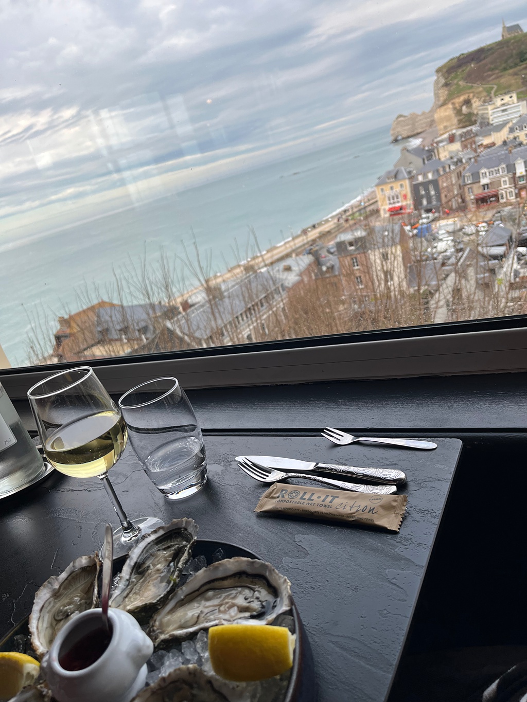 Local Normandy oysters with a view of the white cliffs and town of Etretat, made famous by Monet