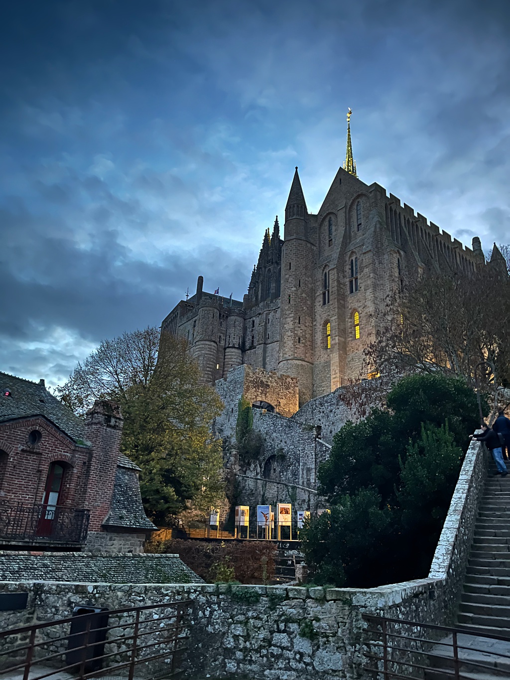 The imposing gothic castle style facade of Mont Saint-Michel in Normandy at dusk