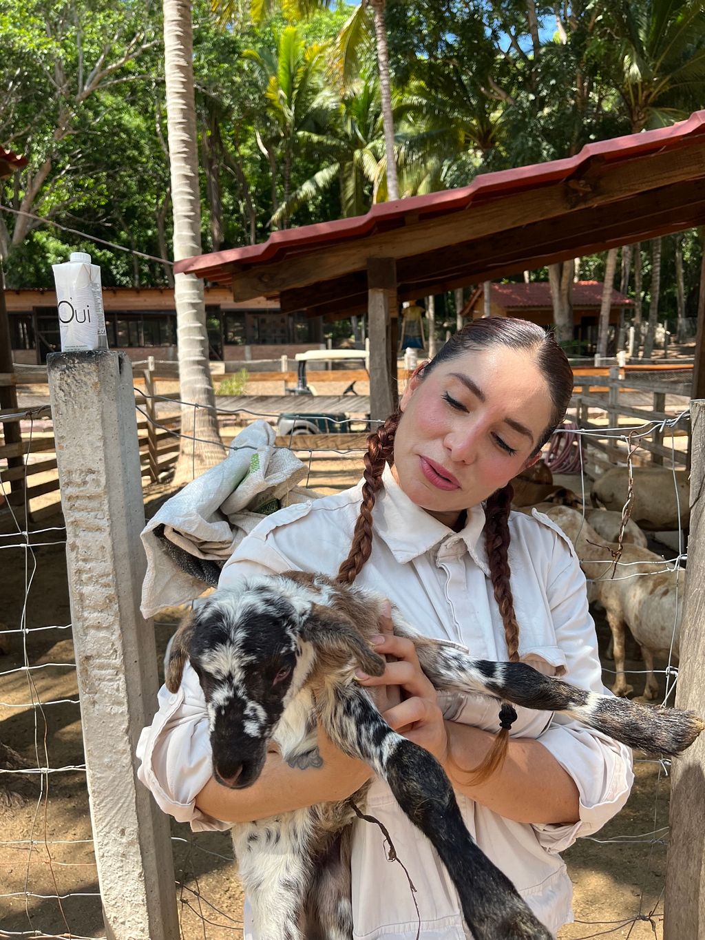 Staff member Judith at Rancho Lola on the onsite farm, holding a newborn lamb